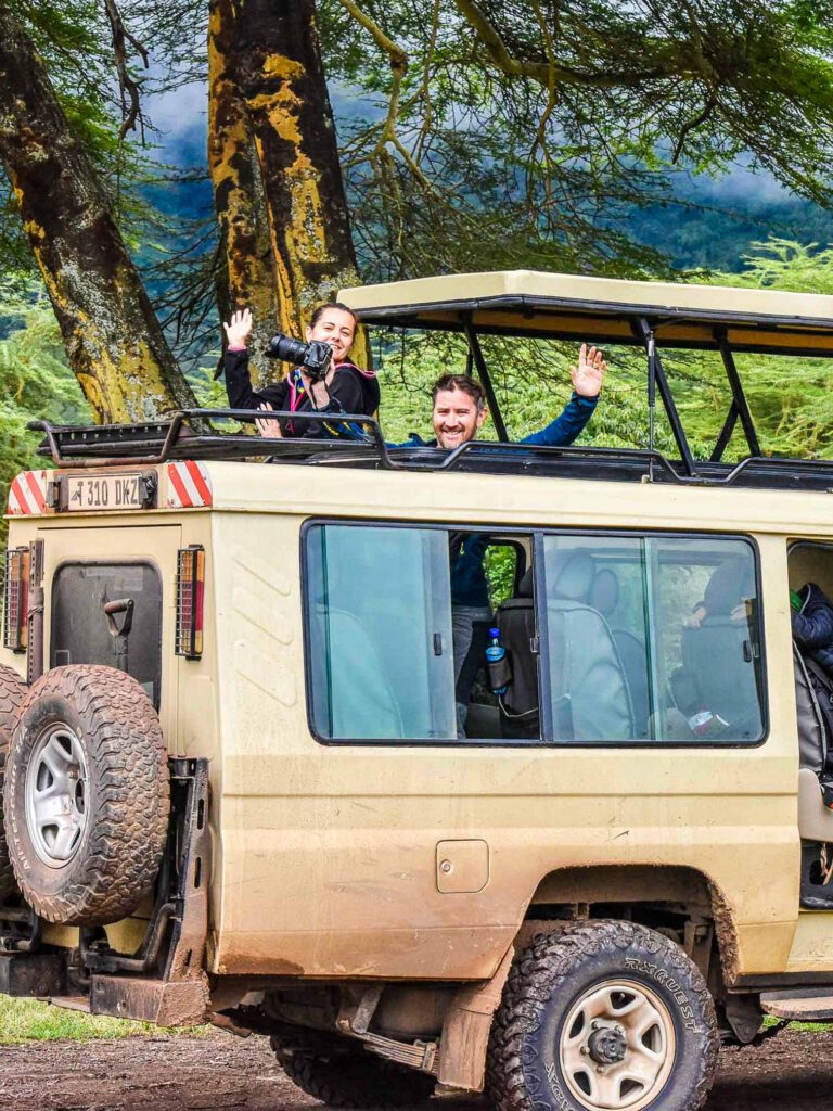 Guests watching wildlife with binoculars from a Charles Tours safari vehicle